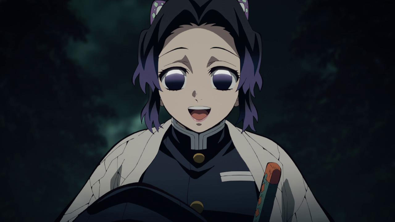 Shinobu Kocho, a character from the anime Demon Slayer, is shown engaged in a happy conversation with someone. She has short, black hair and is wearing her Demon Corps uniform. 